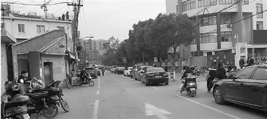 上下學(xué)期間，西行路無論機動車非機動車都不允許停靠。白色圍欄是學(xué)生在校門和停車場之間的“安全通道”。溫雨昕 攝