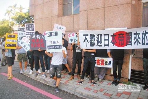 日本核災食品輸臺公聽會花蓮場爆發沖突，場外有反對民眾持標語抗爭。(圖片來源：臺灣《中國時報》)