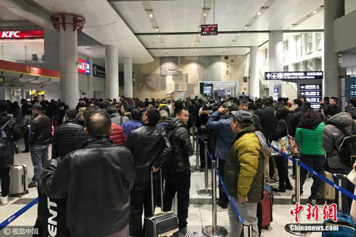 12月20日清晨，北京，受大霧天氣影響，首都機(jī)場(chǎng)多個(gè)航班出現(xiàn)延誤、取消等情況，退票改簽的乘客在首都機(jī)場(chǎng)航站樓前排起了長(zhǎng)隊(duì)。圖片來(lái)源：視覺(jué)中國(guó)