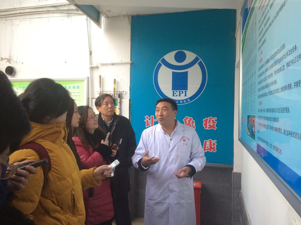 陜西省安康市茨溝鎮中心醫院院長晏顯興（右）在向記者介紹如何破解農村醫療難題。后排右二為陜西省衛生計生委副主任陳昭。人民政協網記者張春莉  攝