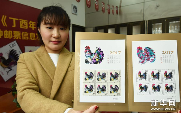1月3日，杭州郵票公司工作人員展示即將發(fā)行的《丁酉年》生肖特種郵票。（新華社發(fā) 龍巍攝）