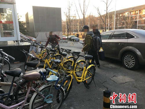 在北京街頭的一處共享單車停車點(diǎn)，有小孩在嘗試解鎖。湯琪 攝