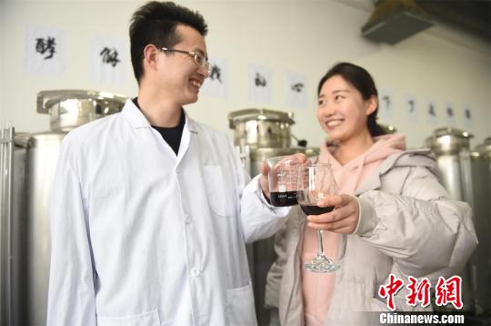 男生把自釀的紅酒送給女生。　侯慶 攝