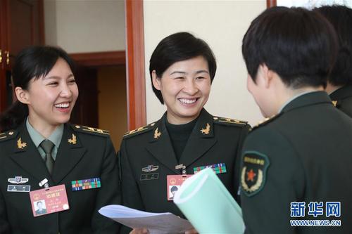 3月7日，全國人大代表劉洋（左二）等在解放軍代表團(tuán)小組會議間隙交流。在兩會會場內(nèi)外，女代表、女委員、女工作人員、女記者在工作中盡職盡責(zé)，展現(xiàn)著自己的風(fēng)采。 新華社記者 李剛 攝