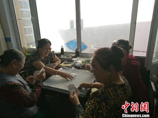 圖為進城牧民在一起打撲克?！±類燮?攝
