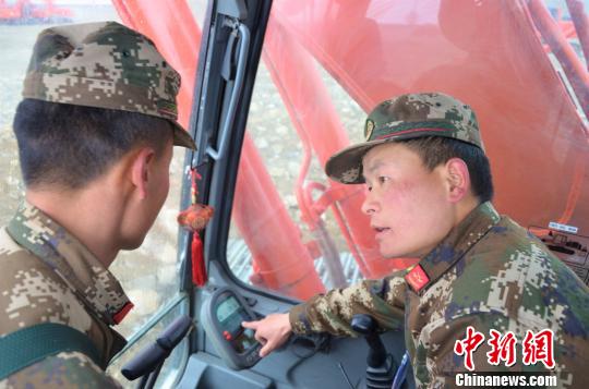 武警交通第二支隊四大隊達東村訓練基地挖掘機二班班長張凱華(右)手把手教學員操作細節 郭江宸 攝