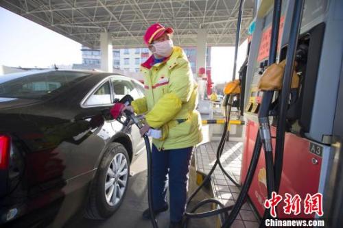 資料圖：山西太原，加油站工作人員正在給車輛加油。張?jiān)?攝