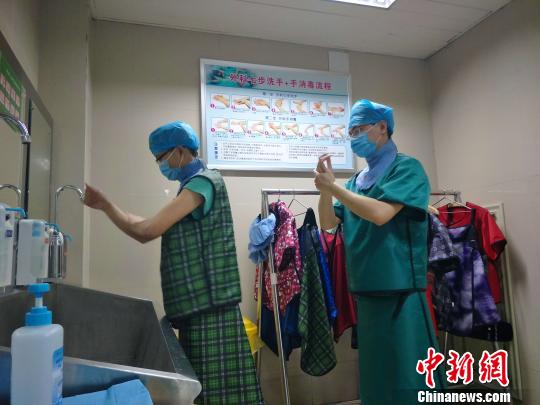 身穿30多斤重的鉛衣的醫(yī)務工作者，剛做完一臺心臟介入手術，正在洗手，準備進行下一臺手術。　崔濤　攝