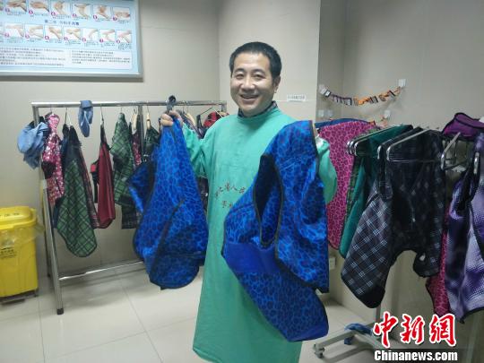 黨懿展示心內(nèi)科醫(yī)生做心臟介入手術時需要穿的鉛衣，全套共重36斤。　崔濤 攝