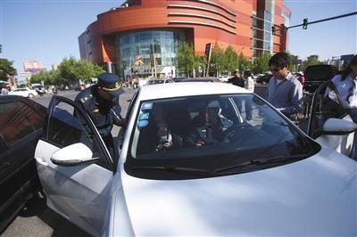 4月24日，交通執(zhí)法人員在朝陽大悅城附近，對一輛非法營運車輛進行查處。新京報記者 王貴彬 攝