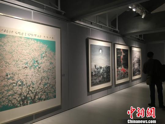 “彩·墨之境——鄧建強作品展”現場，觀眾在《春上暖陽》等四幅作品前駐足觀賞。　劉賢　攝