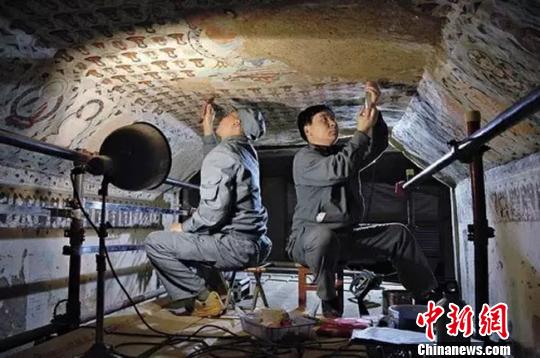 圖為敦煌守護(hù)者在修復(fù)壁畫(huà)。敦煌研究院供圖 攝