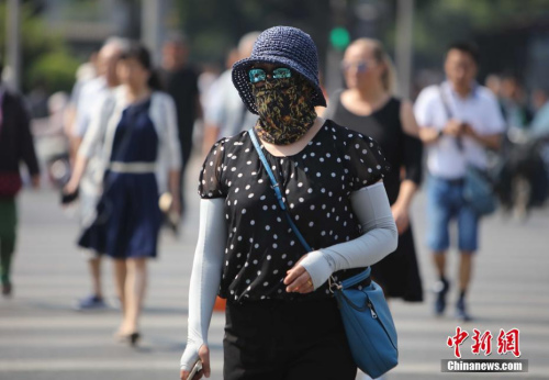 資料圖：5月17日，北京街頭的民眾防曬出行。當(dāng)日北京市氣象臺(tái)發(fā)布今年首個(gè)高溫黃色預(yù)警。<a target='_blank' href='http://www.chinanews.com/'>中新社</a>記者 楊可佳 攝