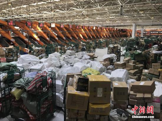 1月20日，湖南長沙郵區中心局的工作人員正在處理堆積的快遞包裹。隨著中國春節的臨近，為了避開實體店購物的擁擠和繁瑣，越來越多的人選擇網絡購置年貨，快遞行業也隨之迎來“春運”高峰。<a target='_blank' href='http://www.chinanews.com/'>中新社</a>記者 唐小晴 攝