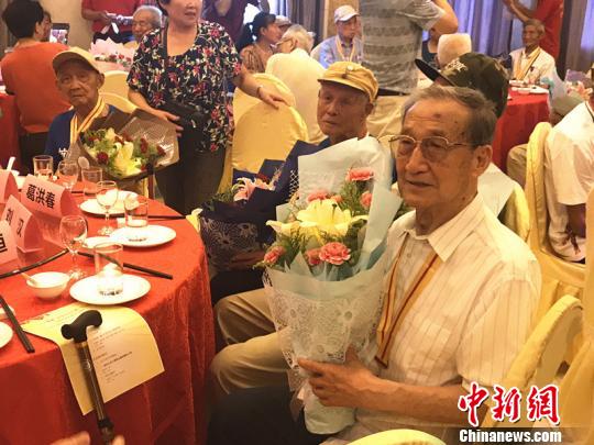 抗戰(zhàn)老兵手捧鮮花。　楊顏慈 攝