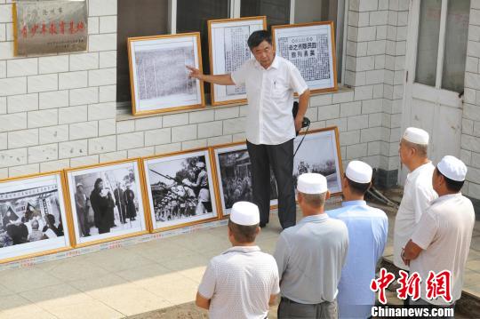 圖為趙文嶺在影展上向參觀者介紹影展展出內(nèi)容。　苑立偉 攝