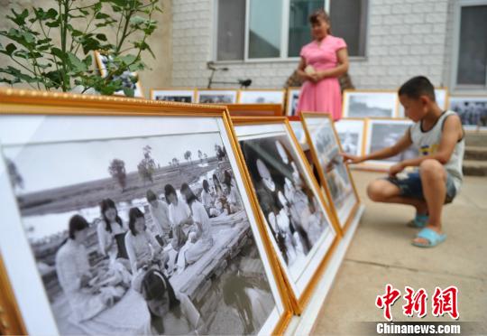 圖為群眾在趙文嶺家中參觀馬本齋與回民支隊事跡圖片展。　苑立偉 攝