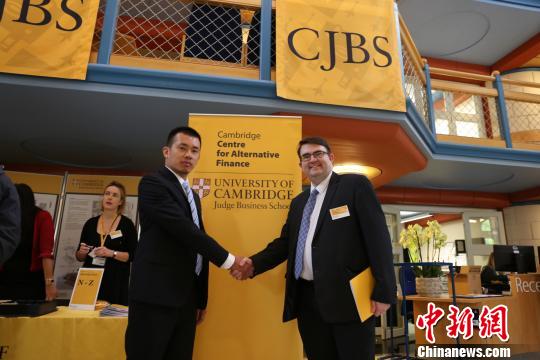 在第二屆劍橋大學替代金融年會上，中國企業代表翁曉奇與英國互聯網金融協會主任Robert Pettingrew深入交流?！＄娦?攝