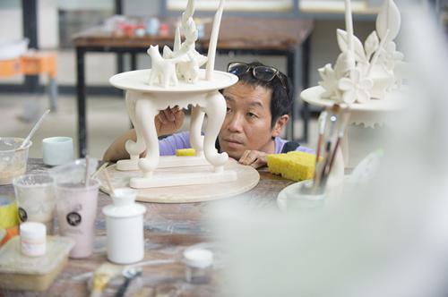 7月6日，來(lái)自韓國(guó)的藝術(shù)家金才圭正完善自己的作品。
