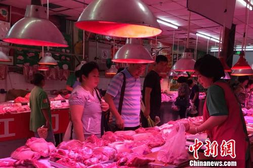 北京陶然亭公園附近一家農(nóng)貿(mào)市場內(nèi)，正有消費者在挑選五花肉。<a target='_blank' href='http://www.chinanews.com/' >中新網(wǎng)</a> 種卿 攝