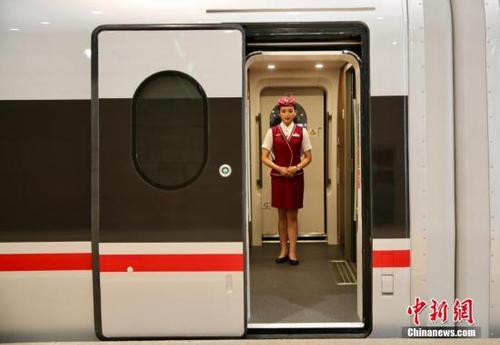 6月26日，在北京南站等待首發(fā)的“復(fù)興號”高鐵動車組乘務(wù)員迎接乘客到來。<a target='_blank' href='http://www.chinanews.com/' >中新網(wǎng)</a>記者 翟璐 攝