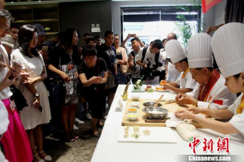 圖為烹飪大師現(xiàn)場(chǎng)廚藝表演，令華裔青年贊不絕口。　崔佳明 攝