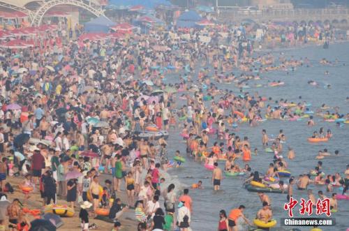 2017年7月12日，青島市第一海水浴場(chǎng)日迎數(shù)萬(wàn)游客前來(lái)避暑納涼。<a target='_blank' href='http://www.chinanews.com/'>中新社</a>發(fā) 王海濱 攝 圖片來(lái)源：CNSPHOTO