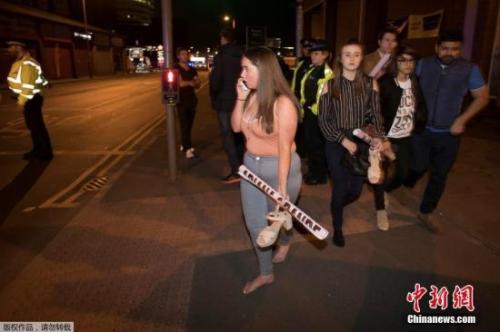 英國曼徹斯特體育館爆炸發(fā)生后，被疏散的歌迷們手里還拿著明星的海報。