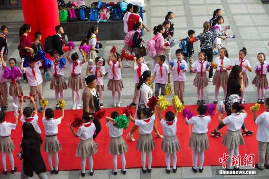 9月10日是一年一度的教師節。9月9日，山西太原新建路小學的教師們在學生們的歡呼簇擁下像明星一樣走紅毯展風采、秀簽名，并接受他們崇高的敬禮與祝福。圖為孩子們夾道歡迎老師走紅毯展風采。張云 攝