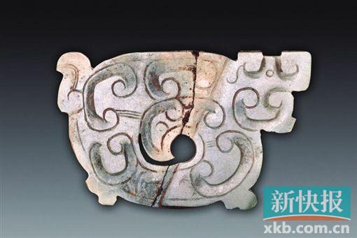 玉龍形飾 春秋 青綠色，薄片體。為長方形，身體卷曲，頭側視，圓形小眼，吻部前伸，下部似有雙足，另一側有一彎尾。一面飾勾云紋，中部身軀鏤空成渦形孔，器物表面有切割痕。另一面光素無紋。春秋時期琢玉技藝有了很大的進步，制出了更為精美的玉器，紋飾從平面向隱起、從簡單到繁復的方向發展，雕刻技法采用浮雕、鏤空與陰刻相結合。