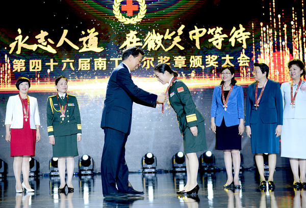 001  中共中央政治局委員、國家副主席、中國紅十字會名譽會長李源潮為中國獲獎者頒發南丁格爾獎獎章。