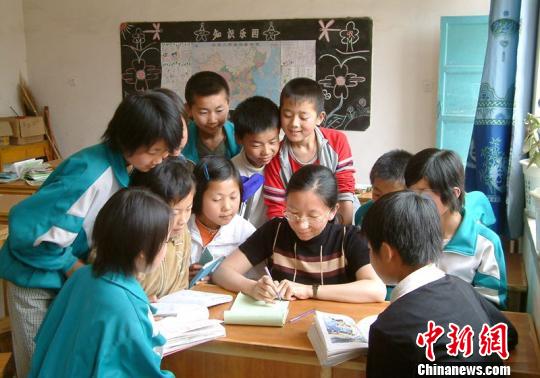 資料圖。圖為張?zhí)m萍給學生們輔導作業(yè)。　鐘欣 攝