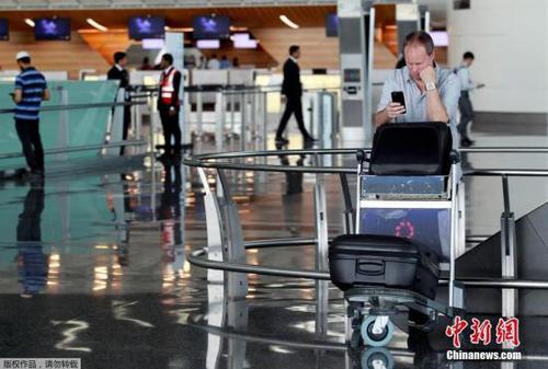 此前，阿聯(lián)酋航空、埃及航空等相繼暫停往返卡塔爾首都多哈的航班，沙特等國甚至禁止卡塔爾航空班機越過領(lǐng)空，令中東航空樞紐多哈的哈馬德國際機場陷入混亂。圖為一名游客在哈馬德國際機場看手機。