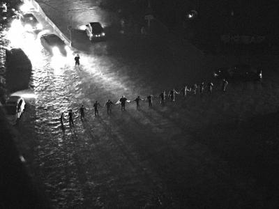 暴雨中，搶險隊員站成“人墻”，引導交通。劉瑜攝 
