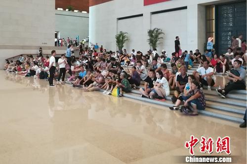 坐在國(guó)博一層大廳臺(tái)階上的人們。上官云 攝