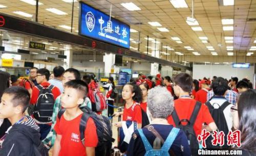 皇崗邊檢站增開通道快速為前往新加坡游學返程的三百余名廣西柳州的小學、中學生旅游團辦理入境手續。　黃俊生 攝