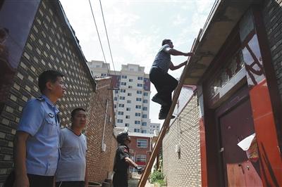 昨日，天津市靜海區王家樓村。一個傳銷窩點大門緊閉，聯合執法人員爬梯子翻墻去開門。