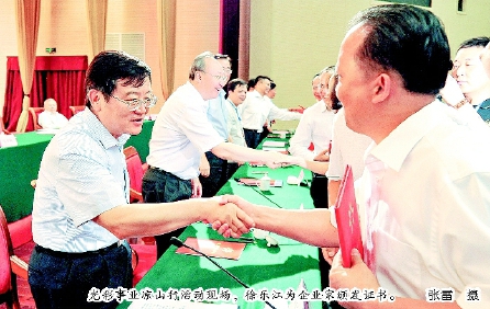 光彩事業涼山行活動現場，徐樂江為企業家頒發證書。  張雷  攝