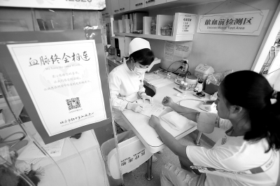 昨天，西單獻(xiàn)血小屋內(nèi)，一名前來無償獻(xiàn)血的女子正在接受化驗(yàn)。這里平常日均獻(xiàn)血人數(shù)有20至30人，暑期以來，每天降至10至15人。 實(shí)習(xí)記者 武亦彬攝