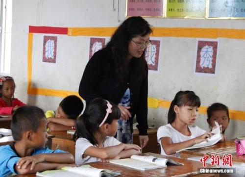 9月22日，在偏遠(yuǎn)山區(qū)的廣西柳江縣穿山鎮(zhèn)六廟小學(xué)，幾間瓦房教室、宿舍，操場上3張乒乓球臺就是學(xué)生和老師的一切。48歲的韋鳳玲在給學(xué)生們上課，“下雨時(shí)，人在上課雨從頭頂落”，韋鳳玲這樣形容學(xué)校環(huán)境。2014年從老撾完成兩年支教任務(wù)的柳江縣第二中學(xué)教師韋鳳玲，又到該縣土博鎮(zhèn)、穿山鎮(zhèn)村級小學(xué)支教，被稱為支教“專業(yè)戶”。朱柳融 攝