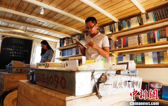 9月5日，海南三亞西島漁村“海上書房”，桌上傳統裝魚的盆被用來放書，年輕人在翻看書籍?！∫Ｃ?攝