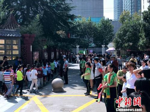 圖為學(xué)校門(mén)口擠滿了學(xué)生家長(zhǎng)。　梅鐿瀧 攝