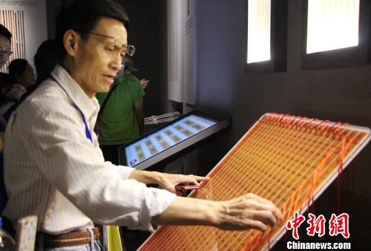 圖為參展觀眾在現場體驗古代算表的計算方式。　趙曉 攝