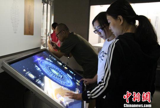 圖為參展觀眾在現場體驗互動模具。　趙曉 攝