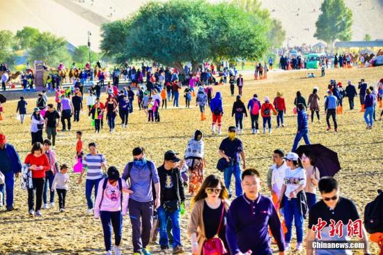 今年“十一”黃金周期間，絲綢之路國際旅游名城甘肅敦煌天氣晴好，景色如畫。敦煌深厚的歷史文化和雄渾的大漠風(fēng)光，吸引了大批海內(nèi)外游客紛至沓來，敦煌旅游再度火爆。10月3日，鳴沙山月牙泉景區(qū)接待游客29524人次，創(chuàng)景區(qū)單日接待游客人數(shù)最高紀(jì)錄。據(jù)敦煌市旅游局統(tǒng)計：截至10月3日，敦煌市共接待中外游客11.07萬人次，同比增長17.14%，實現(xiàn)旅游收入1.12億元，同比增長17.94%。其中，莫高窟接待游客51485人次，同比增長8.45%；鳴沙山月牙泉景區(qū)接待游客65386人次，同比增長13.75%；雅丹景區(qū)接待游客10787人次，同比增長18.93%；陽關(guān)景區(qū)接待8924人次，同比增長48....