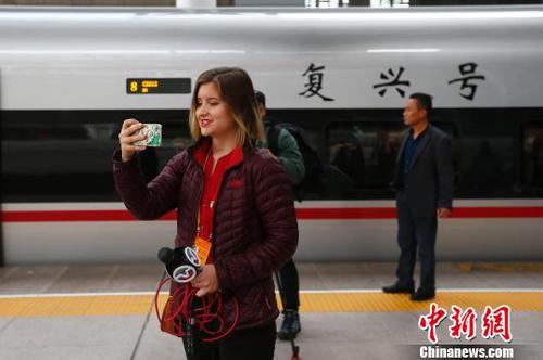 圖為記者在抵達天津后，在車站與高鐵列車“復興號”合影留念。　富田 攝