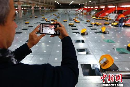 圖為在申通物流公司內，記者在拍攝智能機器人自動分檢系統的工作實況?！「惶?攝