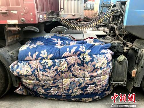 圖為卡車司機用棉被為卡車“取暖”?！＄娦?攝
