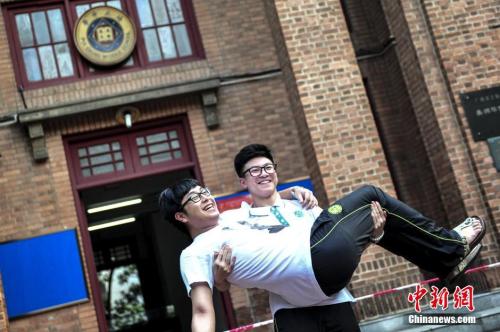 資料圖：一名高考考生抱起同學在考場前合影留念。<a target='_blank' href='http://www.chinanews.com/'>中新社</a>記者 陳驥旻 攝