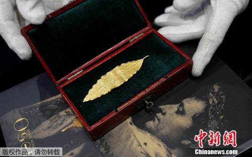 拍賣師展示一片黃金月桂葉，這片金葉子曾是拿破侖加冕禮皇冠上的幾十片金葉子之一。
